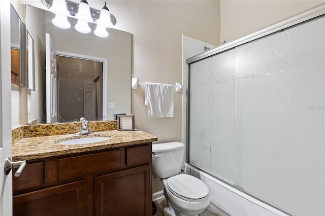 bathroom featuring shower / bath combination with glass door, toilet, and vanity