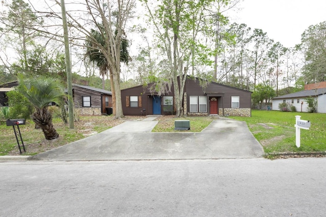 view of front of property with stone siding and a front lawn