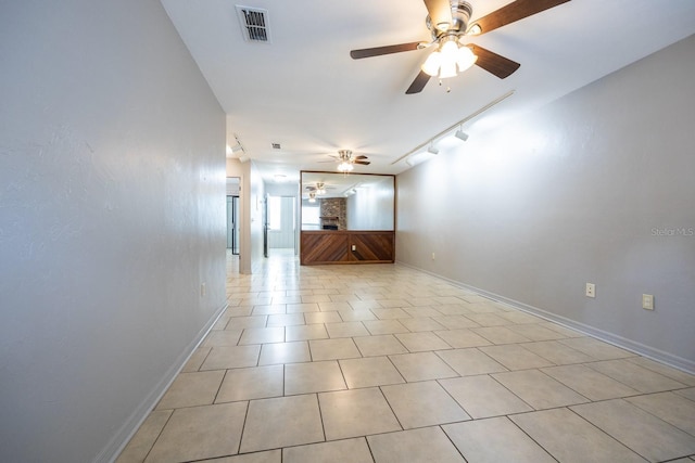 spare room with light tile patterned floors, a ceiling fan, baseboards, visible vents, and track lighting