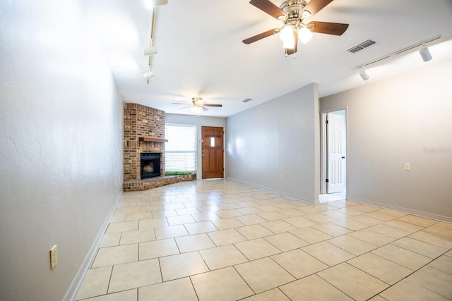 unfurnished living room featuring visible vents, baseboards, ceiling fan, rail lighting, and a brick fireplace