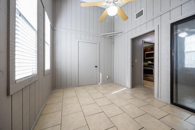 unfurnished room with light tile patterned floors, plenty of natural light, visible vents, and ceiling fan