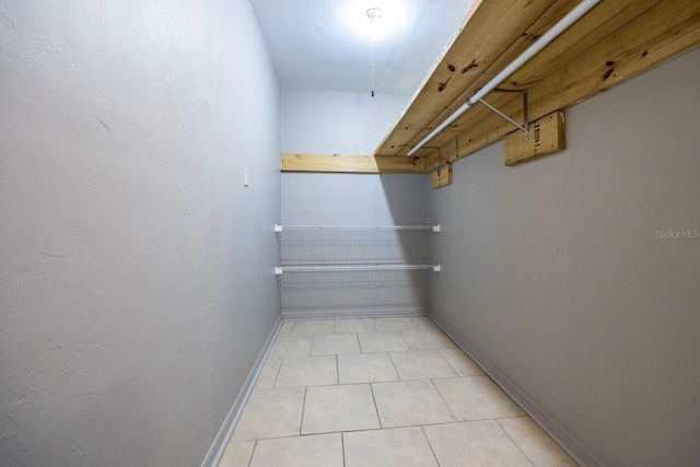 walk in closet with light tile patterned floors