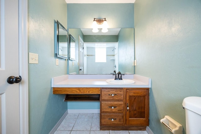 bathroom featuring baseboards, toilet, tile patterned flooring, walk in shower, and vanity