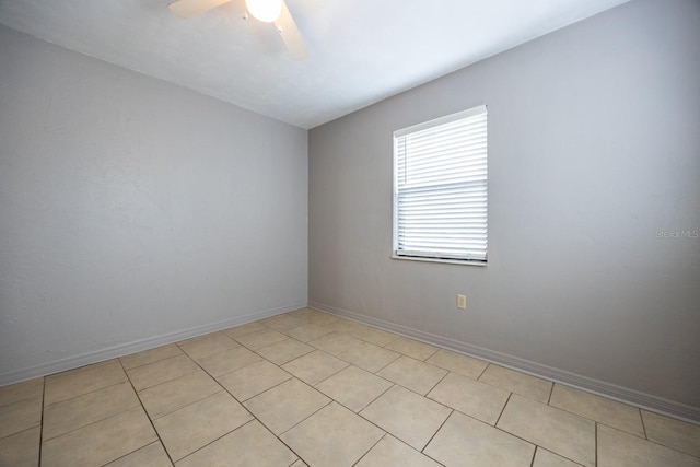 spare room with a ceiling fan and baseboards