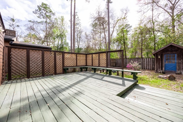 deck featuring a storage shed, an outdoor structure, and a fenced backyard