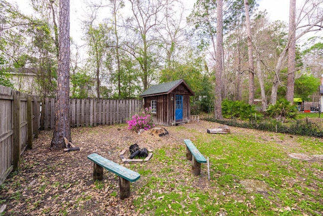 view of yard with an outbuilding, a storage unit, and a fenced backyard