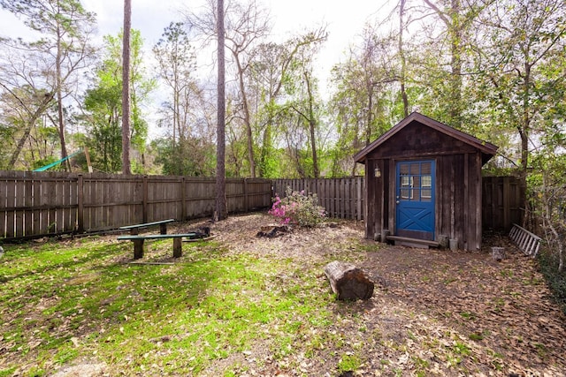 view of yard with an outbuilding, a fenced backyard, and a storage shed