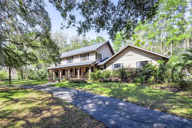 view of front of house featuring a front yard, a porch, and brick siding