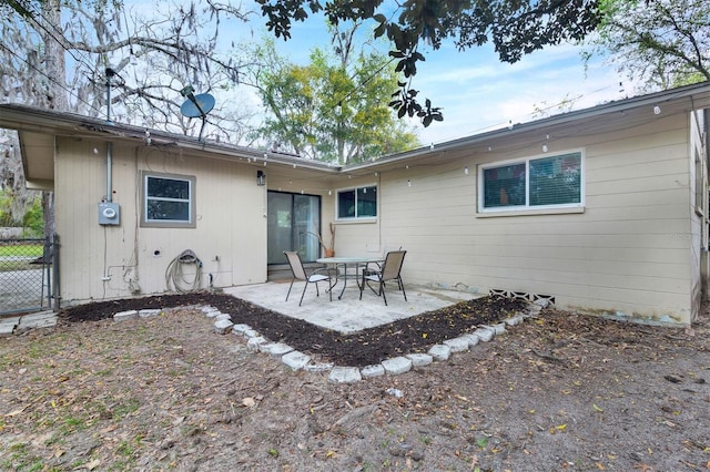 rear view of property featuring fence and a patio