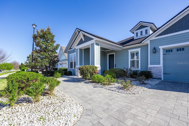 craftsman house with stone siding and an attached garage