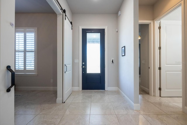 entrance foyer with light tile patterned floors, baseboards, and a barn door