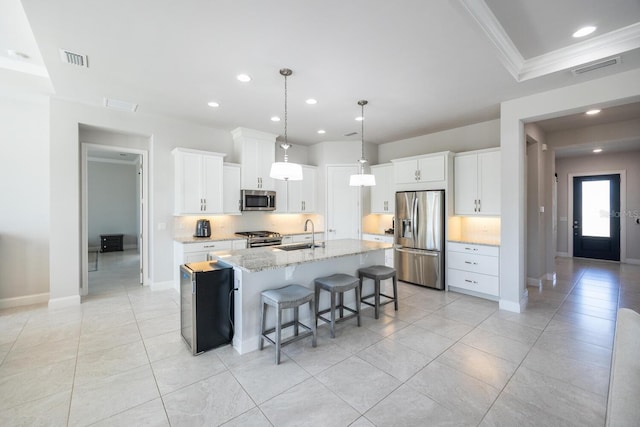 kitchen with a sink, stainless steel appliances, visible vents, and a kitchen island with sink