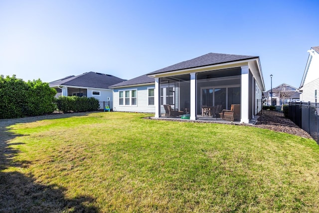 rear view of house with a lawn, a fenced backyard, and a sunroom