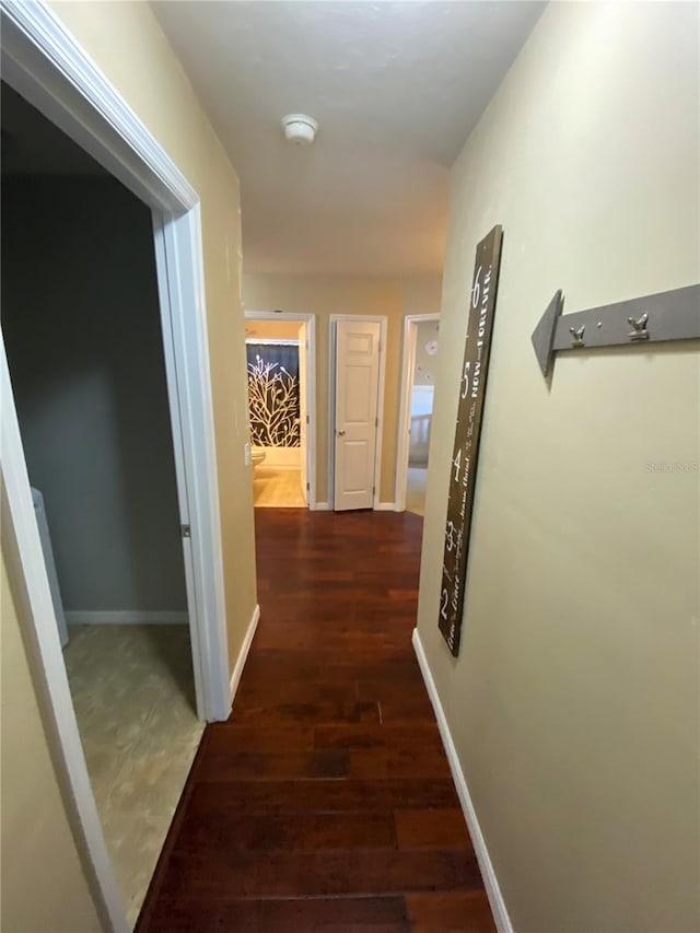 hall featuring baseboards and wood finished floors