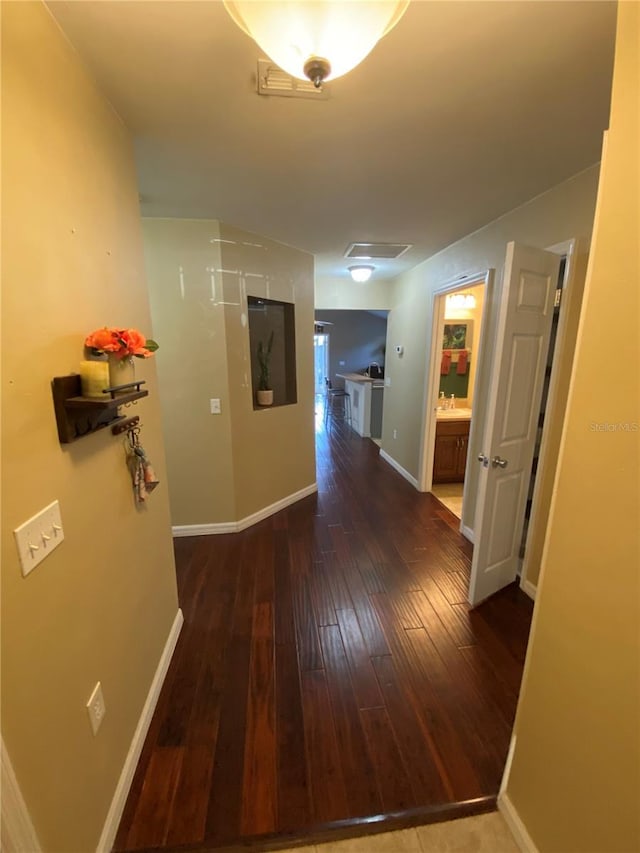 corridor with hardwood / wood-style flooring and baseboards