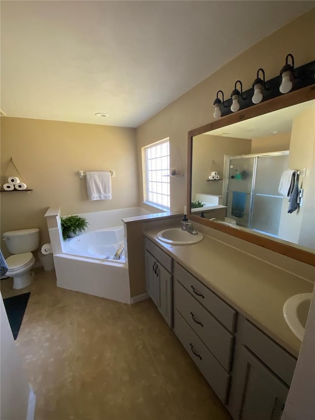 full bath with a garden tub, toilet, a stall shower, a sink, and double vanity