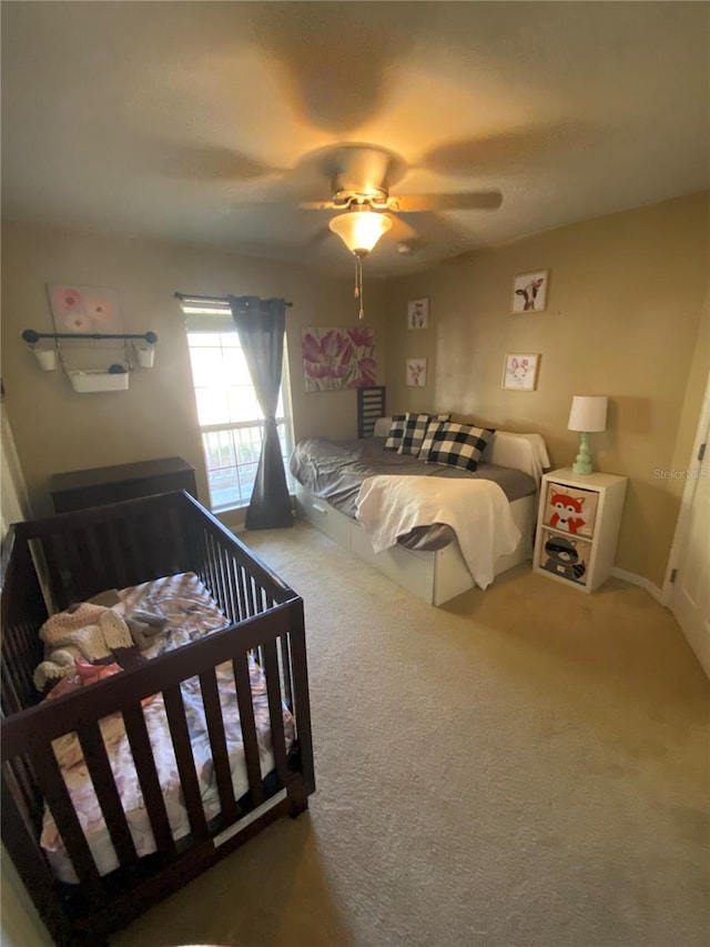 bedroom with a ceiling fan and carpet flooring