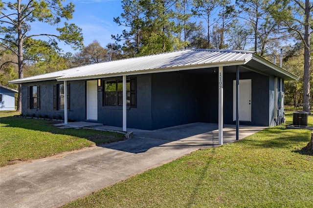 view of front of house with a front yard, metal roof, a carport, cooling unit, and driveway