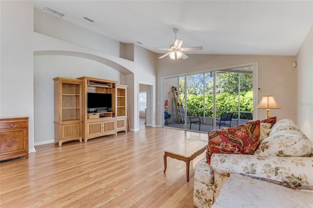 living area featuring a ceiling fan, visible vents, vaulted ceiling, and wood finished floors