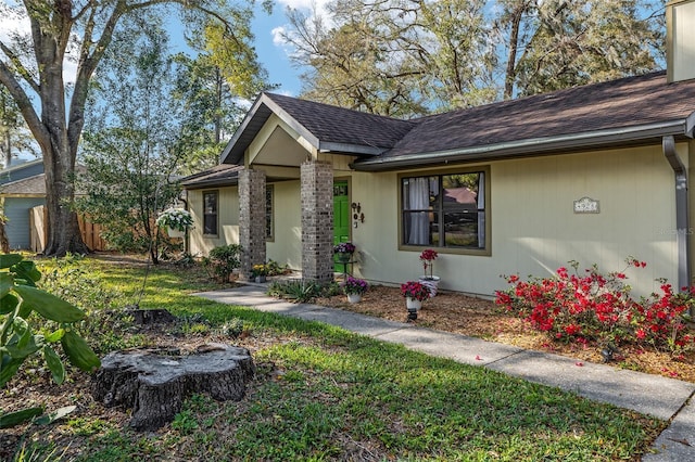 ranch-style home with fence and roof with shingles