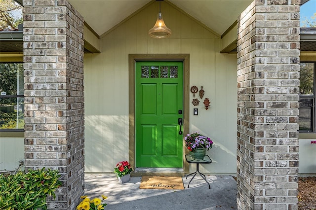 entrance to property featuring brick siding