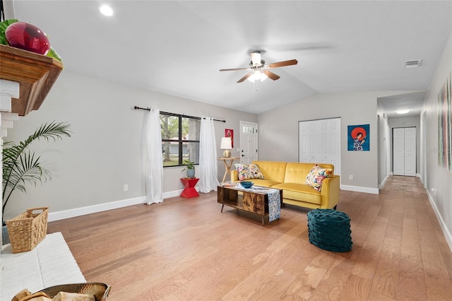 living room with baseboards, lofted ceiling, light wood-style floors, and ceiling fan