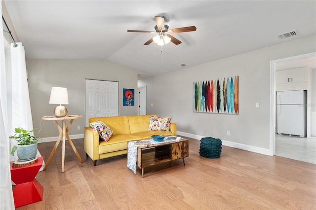 living area with visible vents, ceiling fan, baseboards, lofted ceiling, and wood finished floors