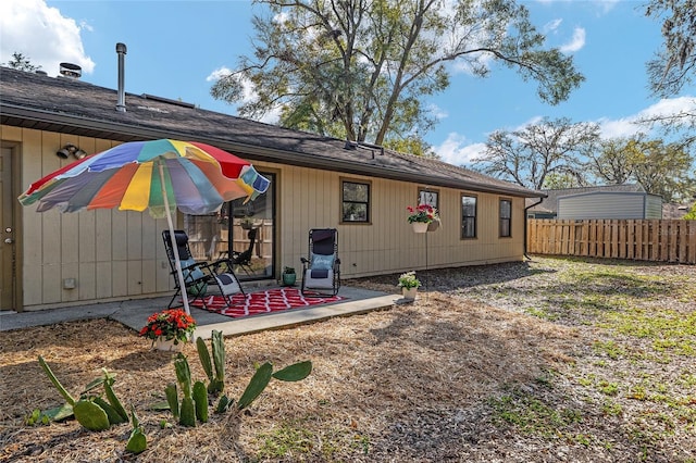 rear view of house featuring a patio and fence