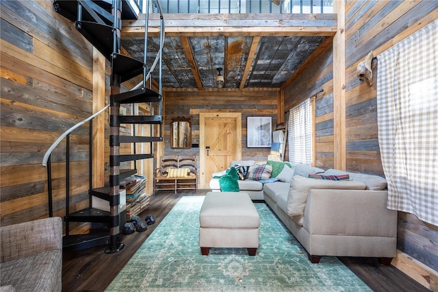 living area featuring wood finished floors, wood walls, and stairs