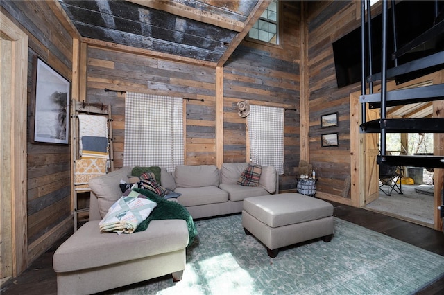 living room featuring wooden walls, a towering ceiling, and wood finished floors