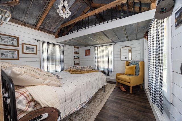 bedroom with vaulted ceiling, wood walls, and wood finished floors