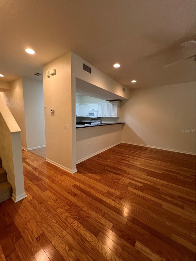 unfurnished room with baseboards, visible vents, wood finished floors, and recessed lighting