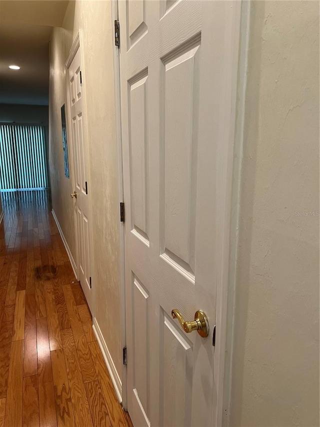 corridor with hardwood / wood-style flooring