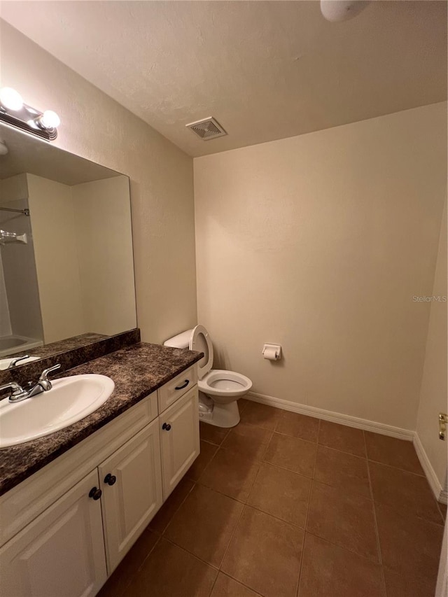 bathroom with tile patterned flooring, baseboards, visible vents, and toilet