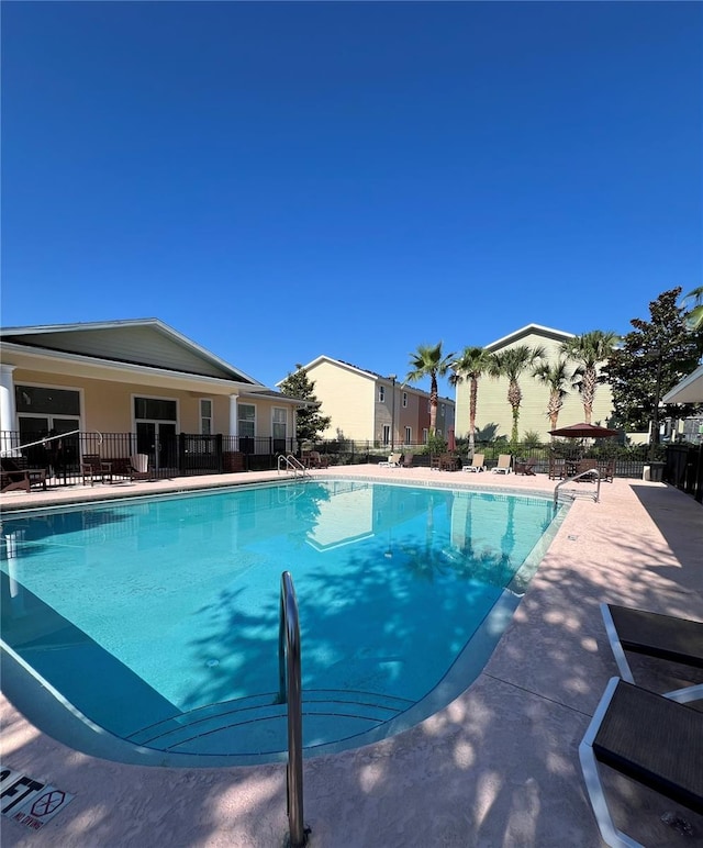 community pool featuring fence and a patio