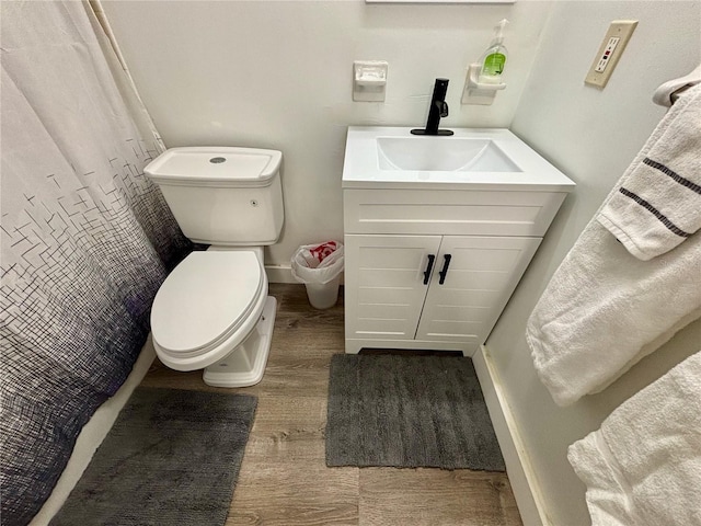 full bath featuring baseboards, vanity, toilet, and wood finished floors