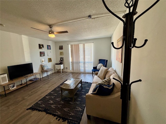 living area featuring ceiling fan, a textured ceiling, and wood finished floors