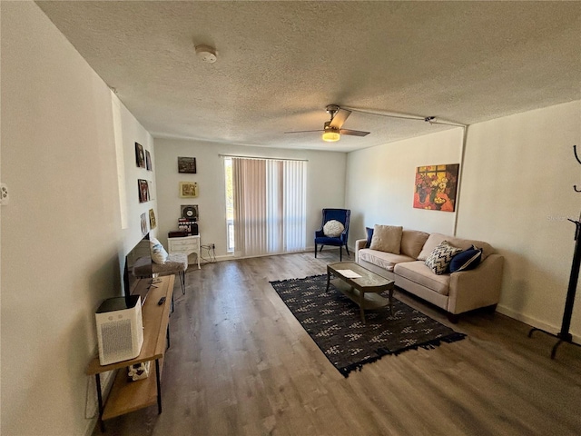 living area featuring a textured ceiling, ceiling fan, and wood finished floors