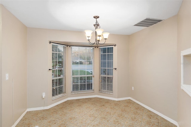 tiled spare room with baseboards, visible vents, and a chandelier