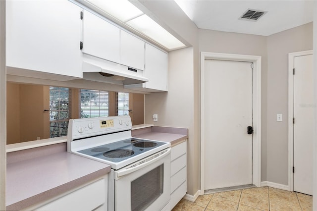 kitchen featuring visible vents, under cabinet range hood, light tile patterned floors, electric range, and white cabinetry