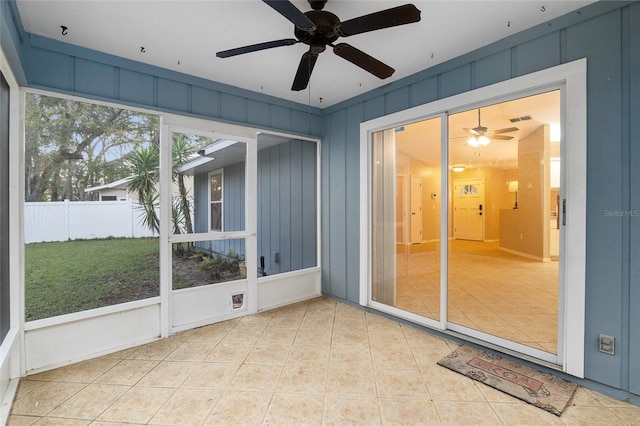 unfurnished sunroom with a ceiling fan