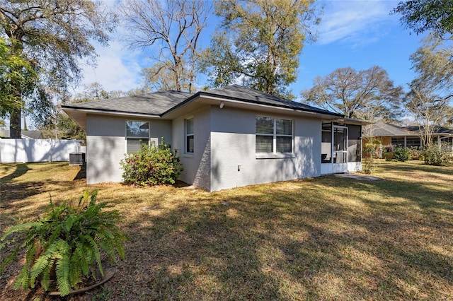 1762 NE 39th St, Ocala, FL 34479 - rear view of property with central air condition unit, fence, a sunroom, a lawn, and stucco siding