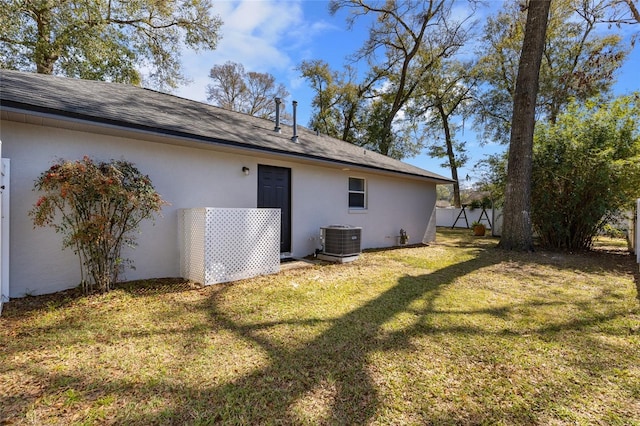 1762 NE 39th St, Ocala, FL 34479 - rear view of house with central AC unit, a lawn, a shingled roof, and stucco siding