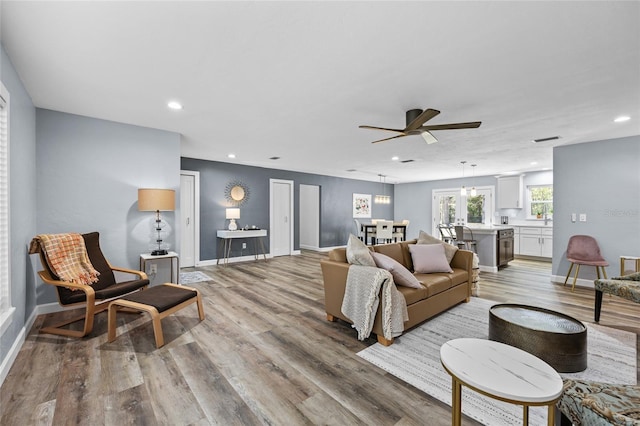 living area with light wood-style floors, recessed lighting, and baseboards