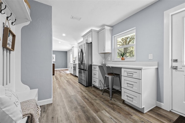 office area with recessed lighting, visible vents, dark wood-type flooring, built in study area, and baseboards