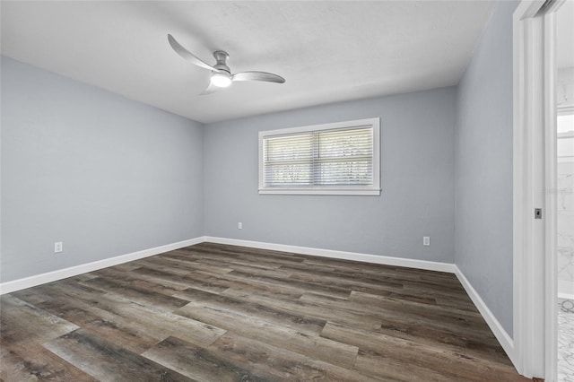 spare room featuring dark wood-style floors, ceiling fan, and baseboards