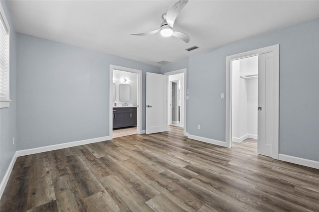 unfurnished bedroom with dark wood-type flooring, visible vents, and baseboards