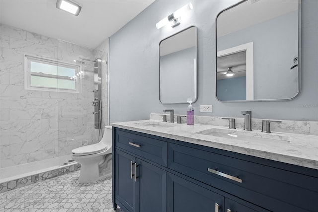 bathroom featuring double vanity, a stall shower, a sink, and toilet