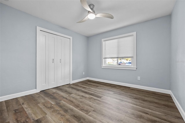 unfurnished bedroom featuring a ceiling fan, a closet, baseboards, and wood finished floors