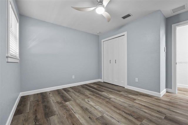 unfurnished bedroom with visible vents, baseboards, and wood finished floors